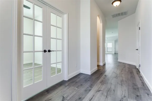 a view of empty room with wooden floor and fan