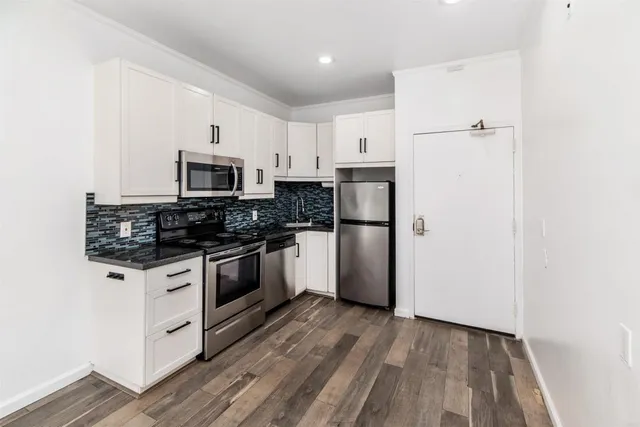 a kitchen with white cabinets and stainless steel appliances