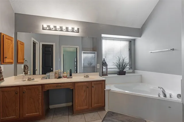 a bathroom with a bathtub a double vanity sink and a mirror