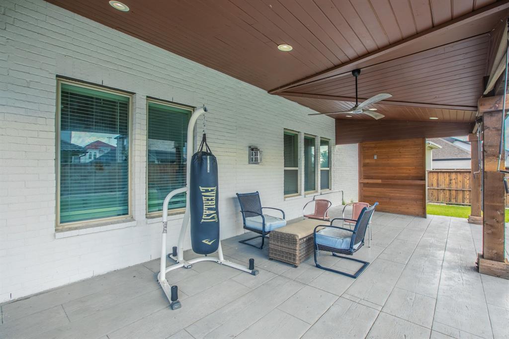 2521 Maidenhair Road Frisco, TX 75033 - Photo 37 of 39 Covered patio with stamped concrete flooring, white brick exterior, wood-paneled ceiling with recessed lighting and a ceiling fan, and wood accent wall