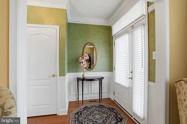 a view of a hallway with wooden floor and a potted plant