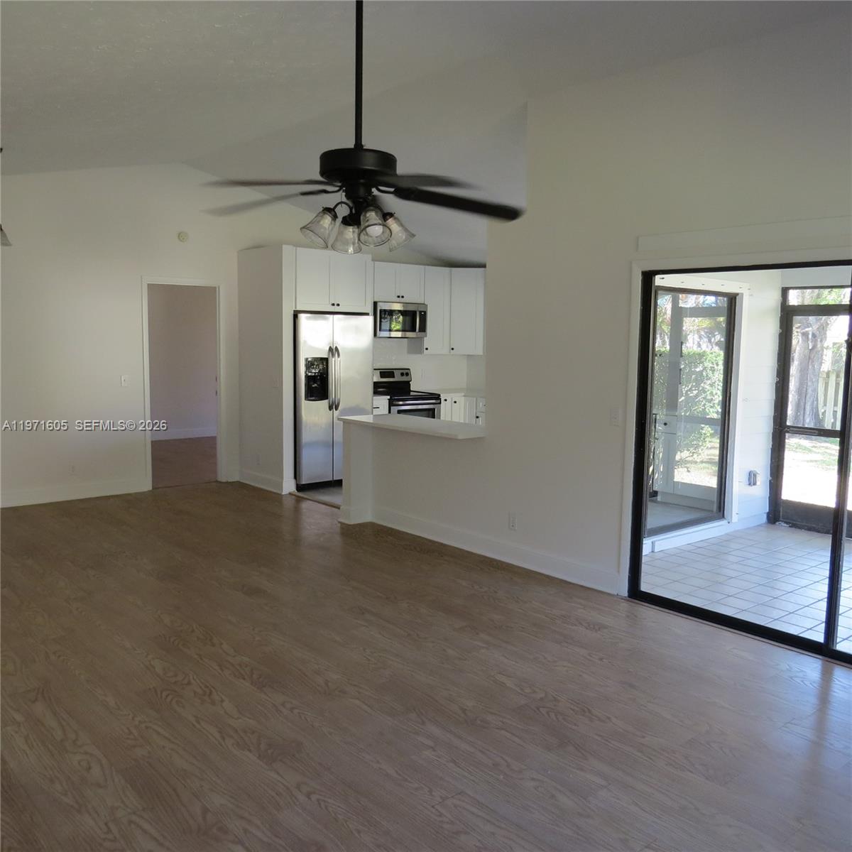 6883 Southeast Raintree Avenue Stuart, FL 34997 - Photo 11 of 32 a view of a kitchen with a sink and a chandelier fan