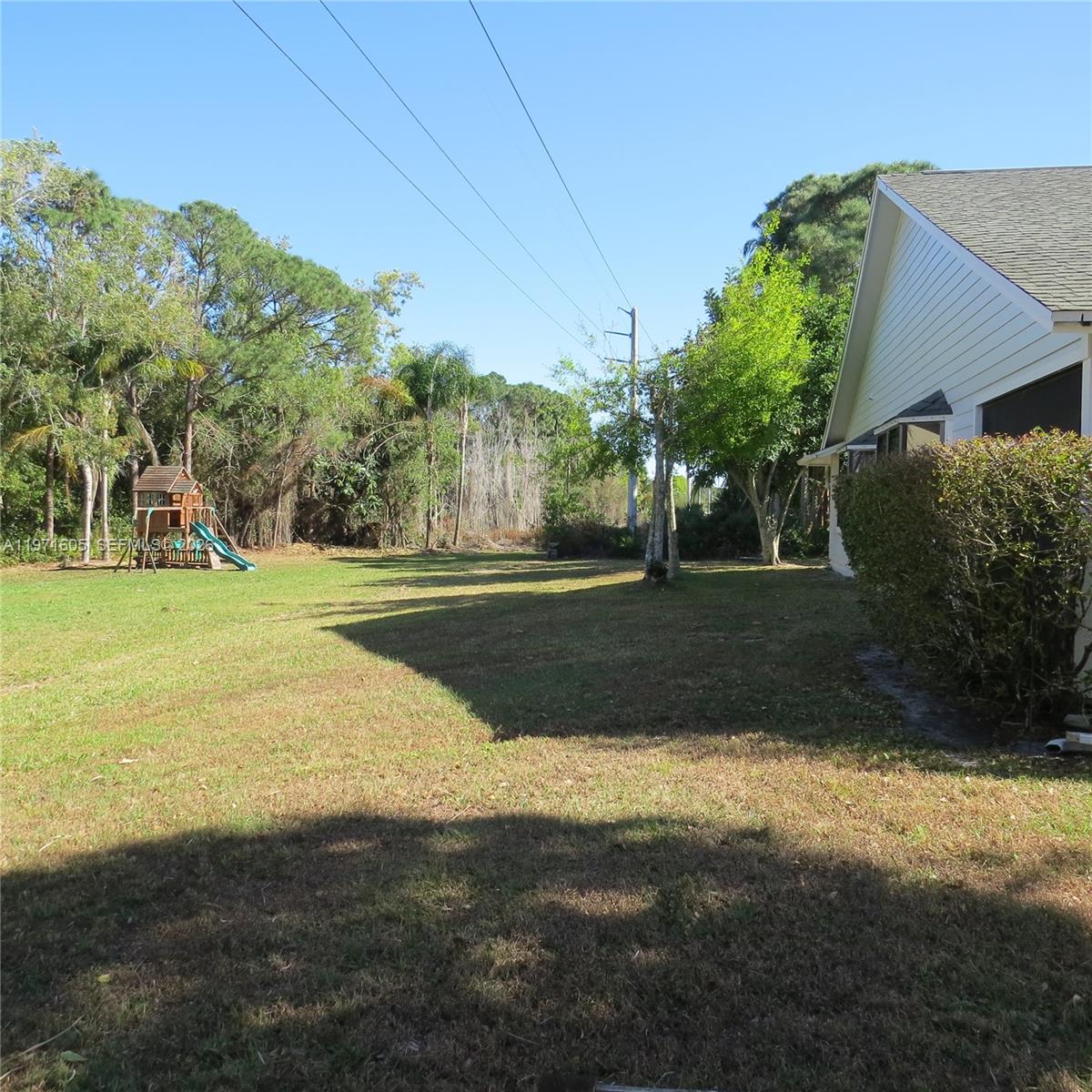 6883 Southeast Raintree Avenue Stuart, FL 34997 - Photo 20 of 32 a view of a field with grass and trees