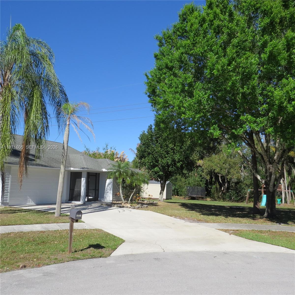 6883 Southeast Raintree Avenue Stuart, FL 34997 - Photo 2 of 32 a view of a patio with a table and chairs under an umbrella