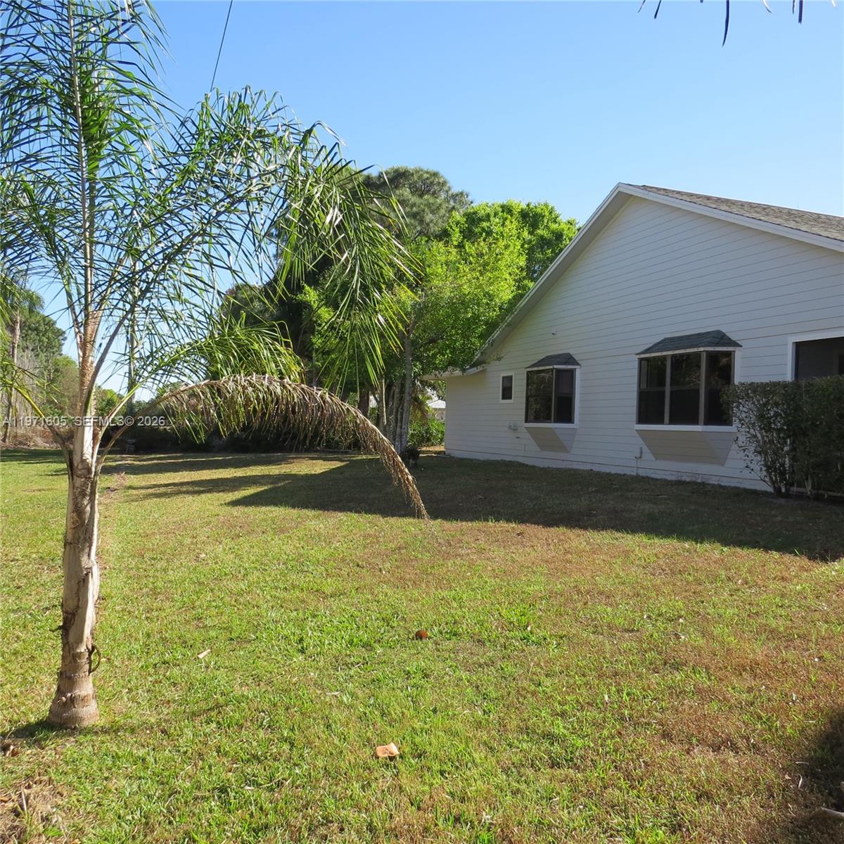 6883 Southeast Raintree Avenue Stuart, FL 34997 - Photo 21 of 32 a house with trees in the background