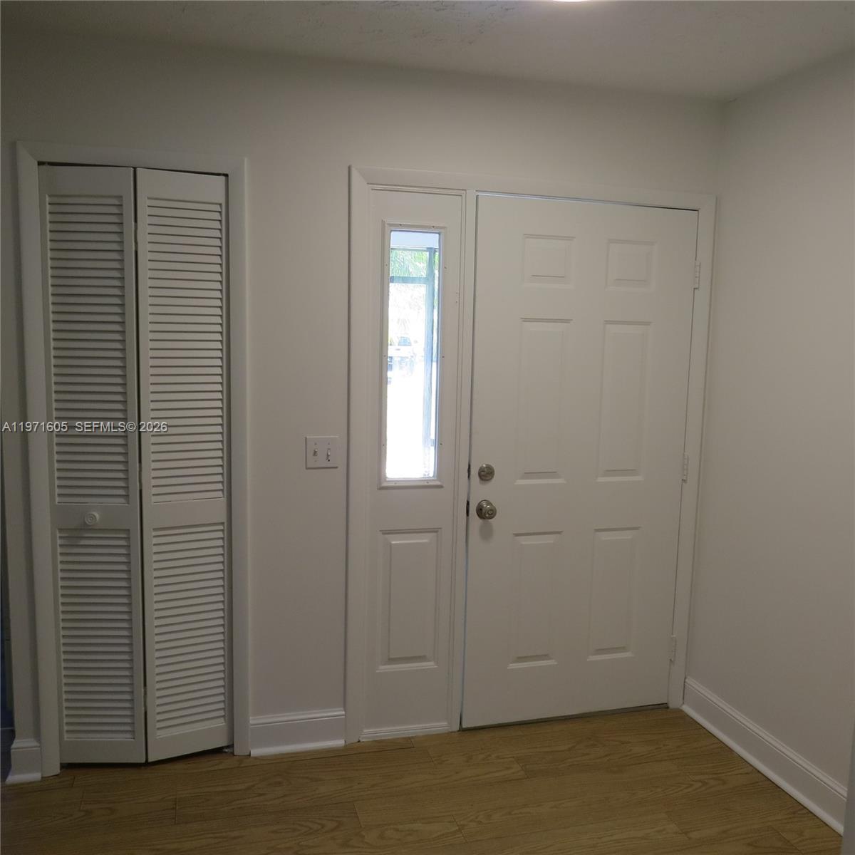 6883 Southeast Raintree Avenue Stuart, FL 34997 - Photo 3 of 32 an empty room with wooden floor and closet door