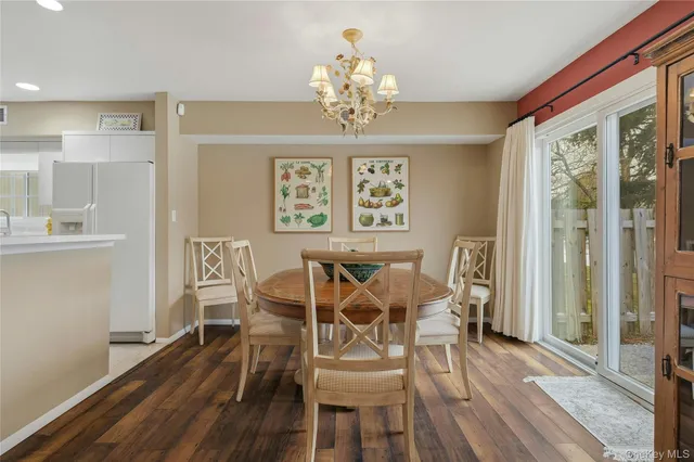 a view of a dining room with furniture a kitchen and chandelier