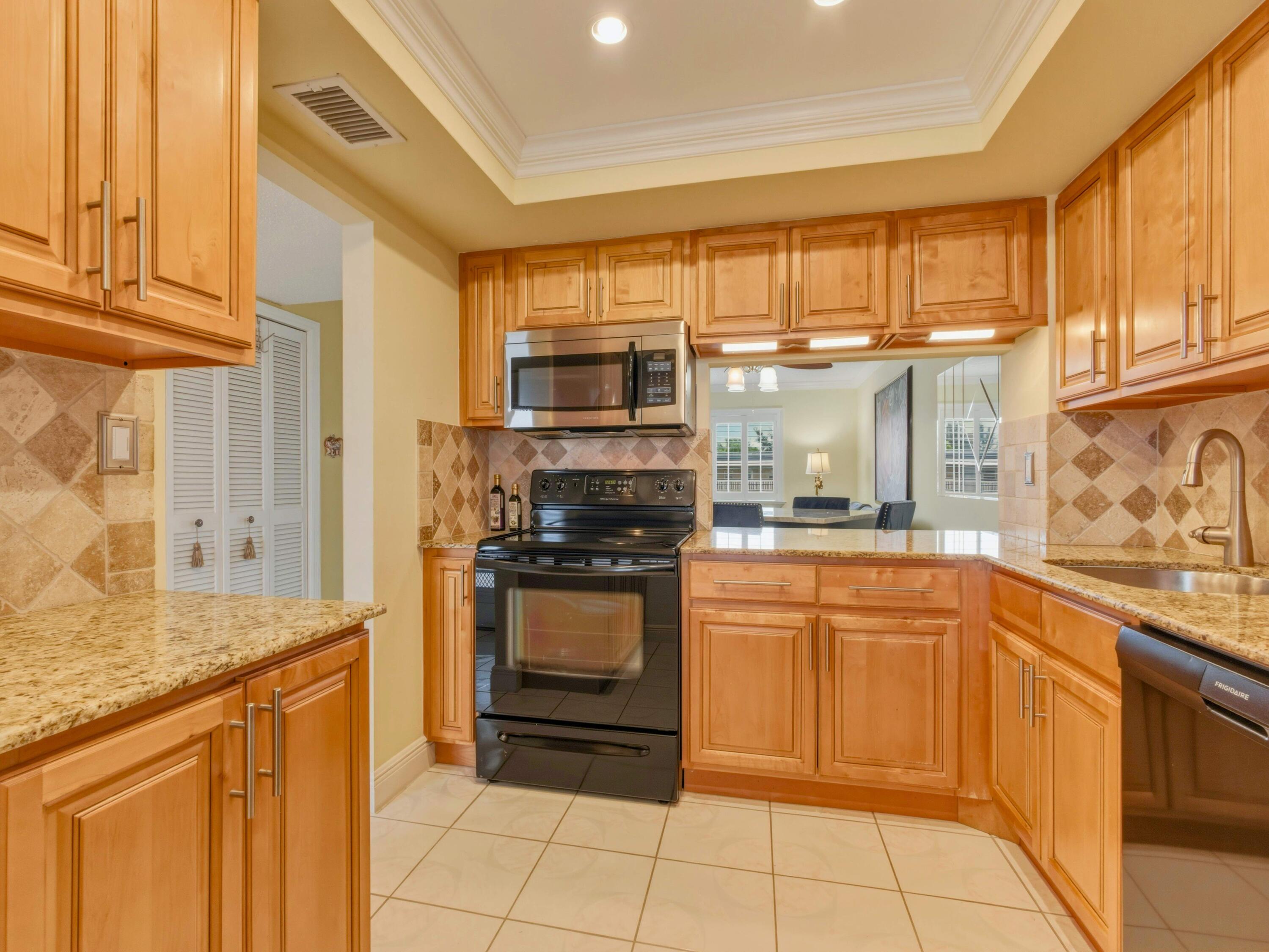 9810 Marina Boulevard, Unit 1136 Boca Raton, FL 33428 - Photo 1 of 35 a kitchen with stainless steel appliances granite countertop a stove and a refrigerator