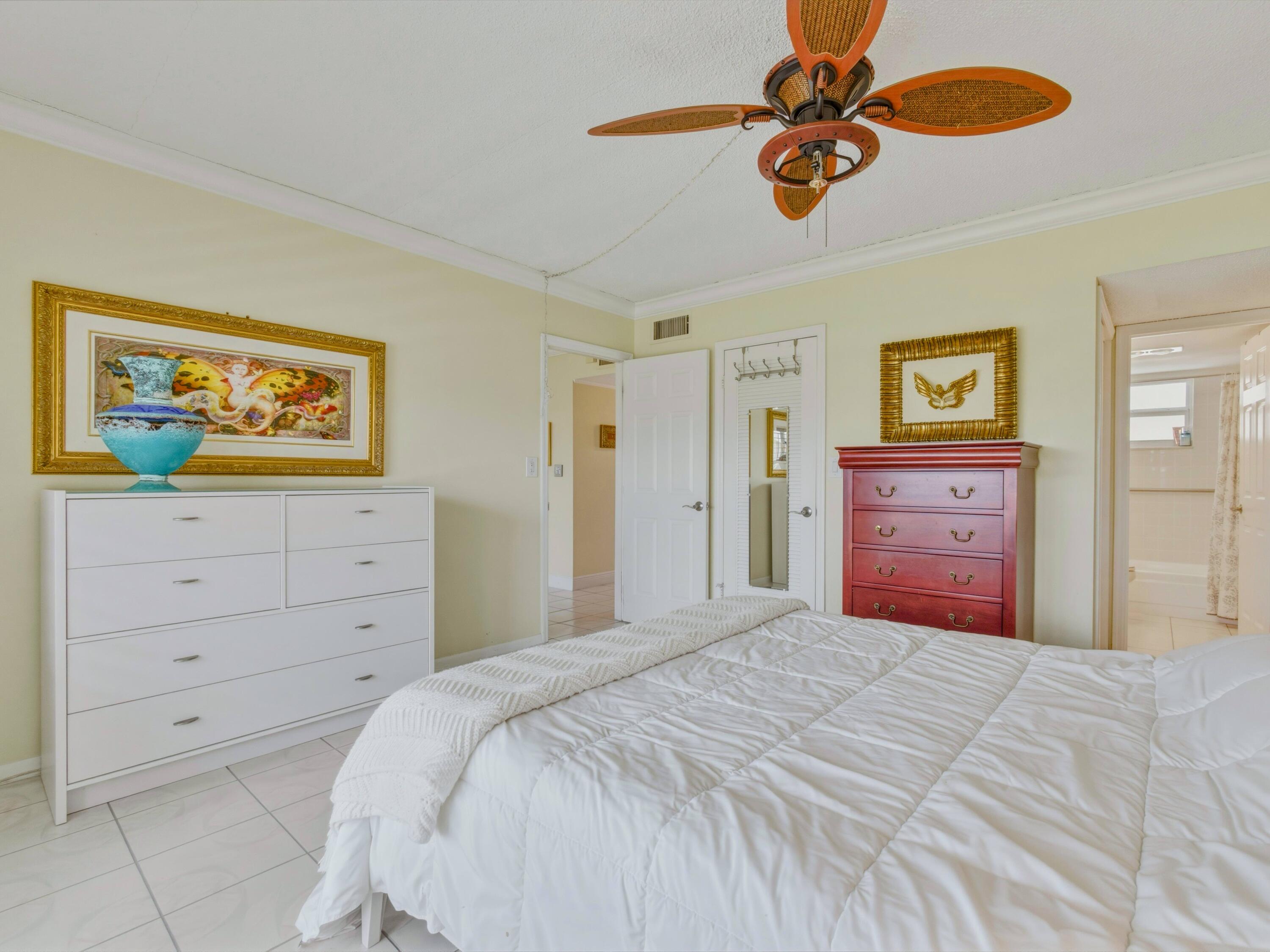 9810 Marina Boulevard, Unit 1136 Boca Raton, FL 33428 - Photo 13 of 35 a bedroom with a bed and a chandelier