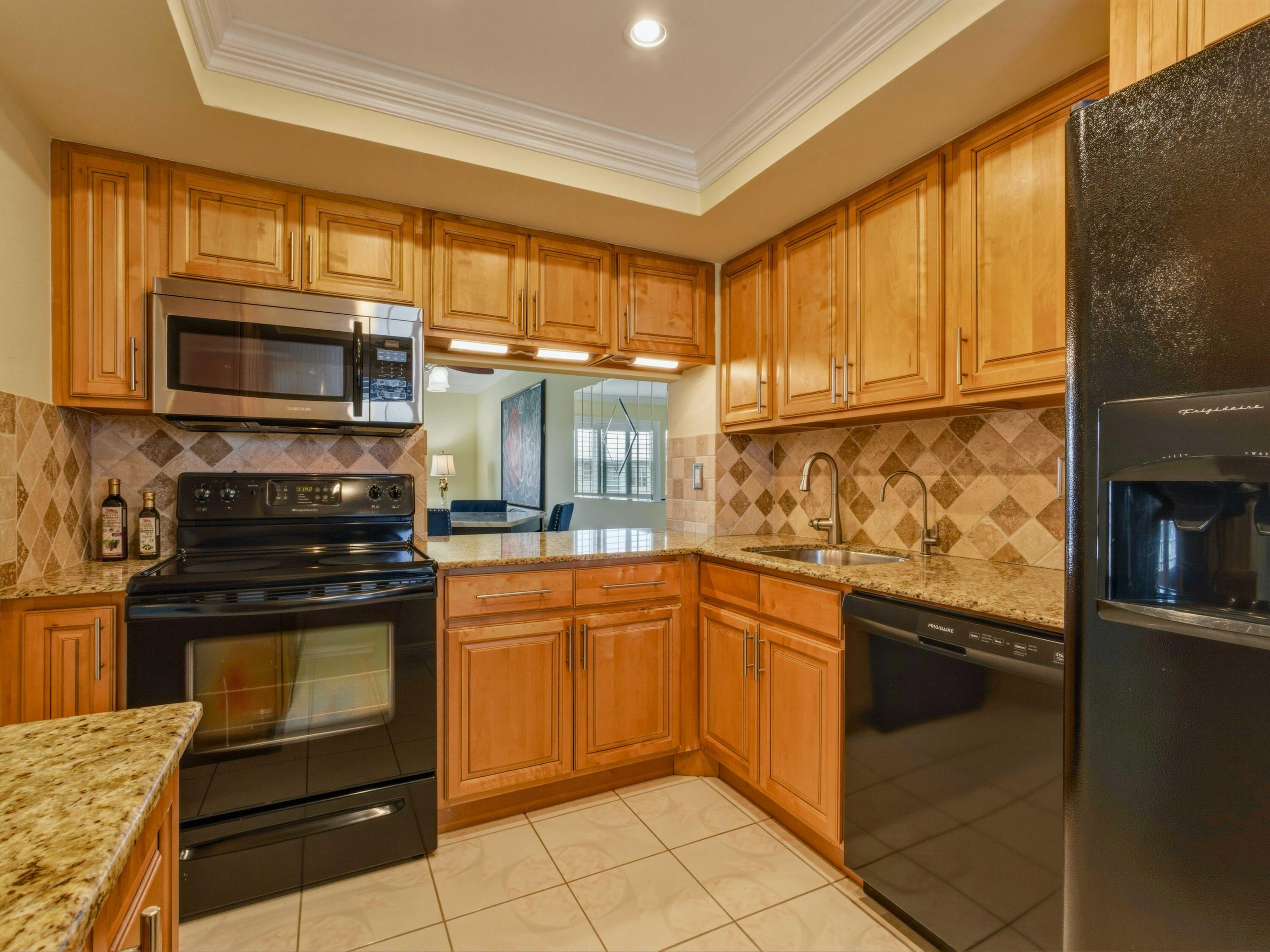 9810 Marina Boulevard, Unit 1136 Boca Raton, FL 33428 - Photo 2 of 35 a kitchen with granite countertop cabinets stainless steel appliances and a counter space