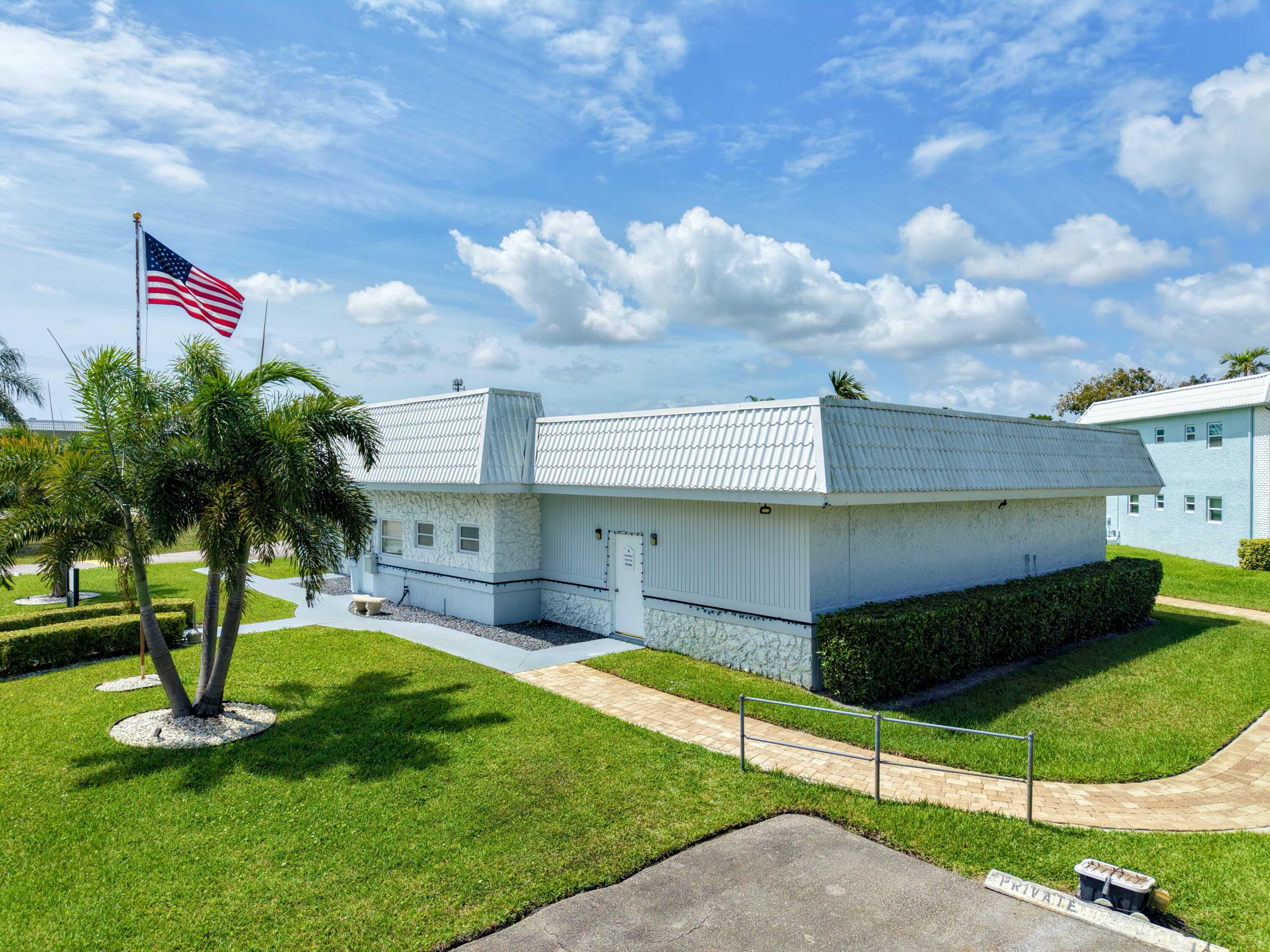 9810 Marina Boulevard, Unit 1136 Boca Raton, FL 33428 - Photo 27 of 35 a front view of a house with a yard and a garage