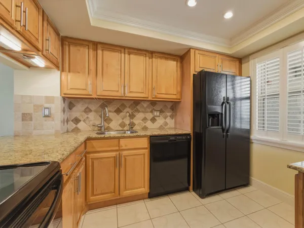 a kitchen with granite countertop a refrigerator and a sink