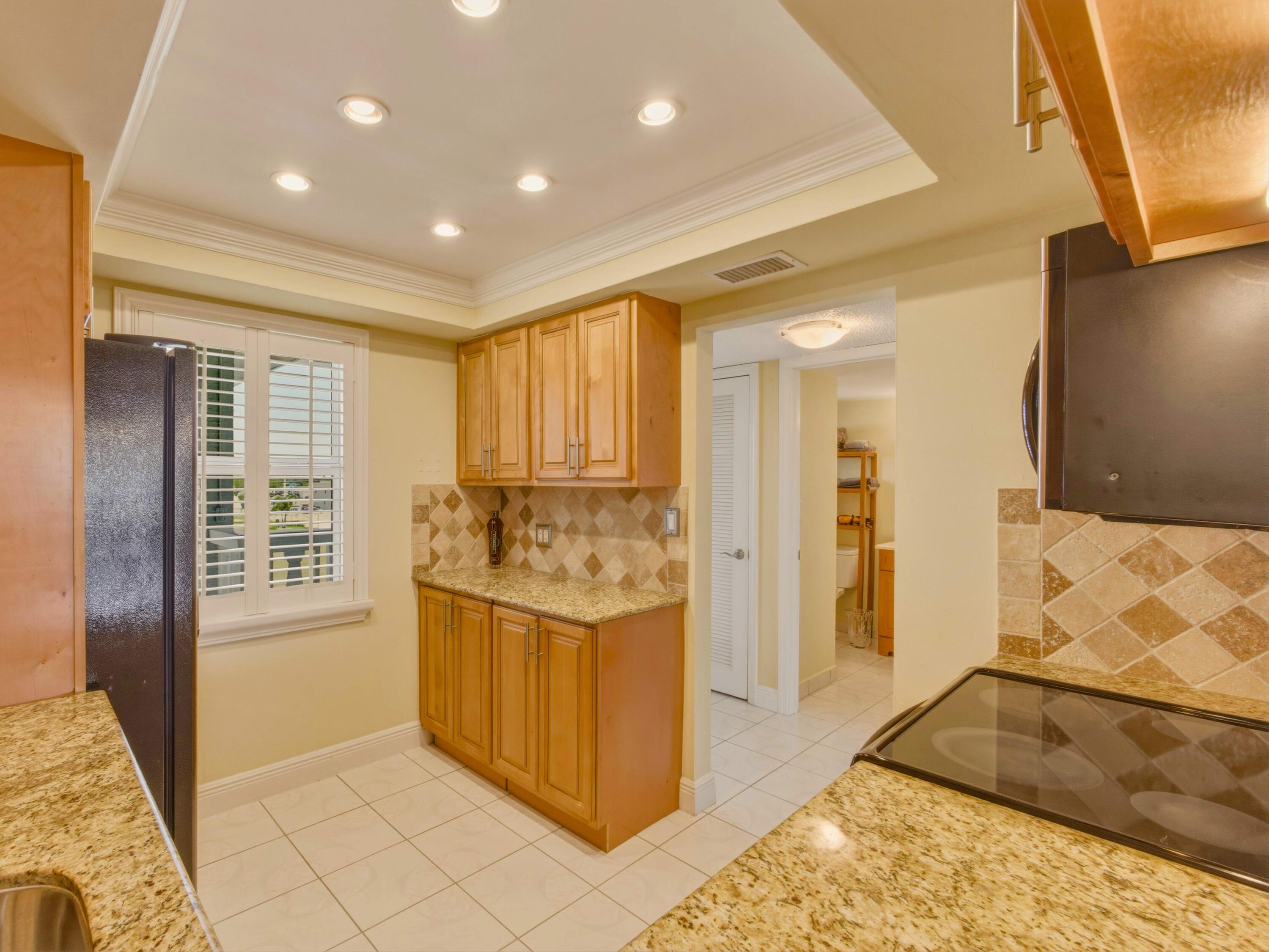 9810 Marina Boulevard, Unit 1136 Boca Raton, FL 33428 - Photo 4 of 35 a view of kitchen with stainless steel appliances granite countertop sink and cabinets