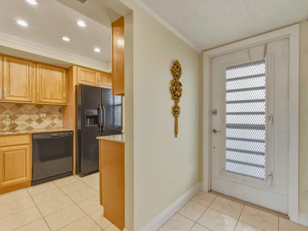 a kitchen with a refrigerator and white cabinets