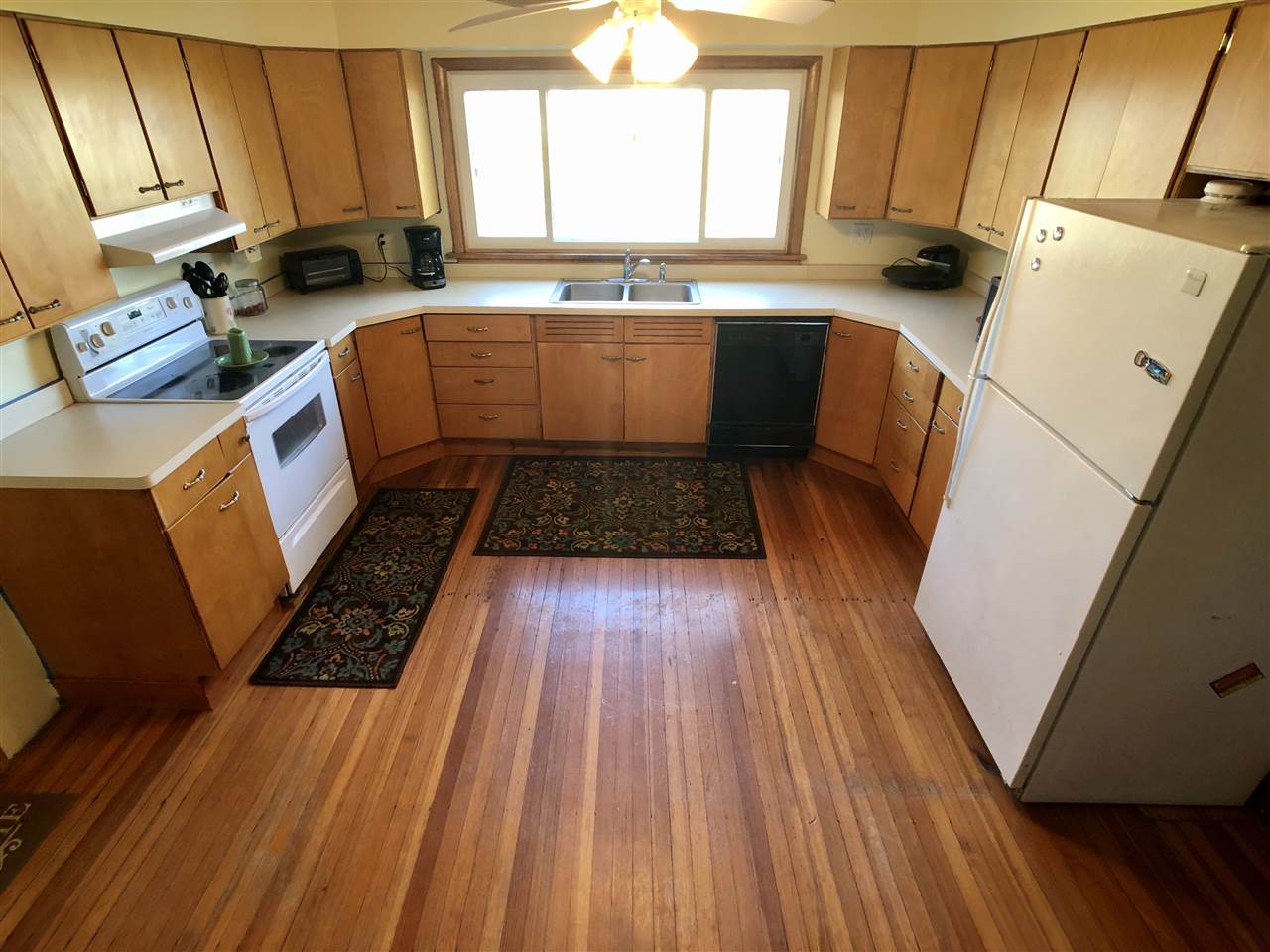 10410 East Flagg Road Rochelle, IL 61068 - Photo 8 of 22 a kitchen with wooden floors and white appliances