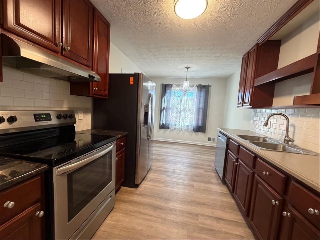3056 Mill Falls Court Duluth, GA 30097 - Photo 11 of 31 a kitchen with stainless steel appliances granite countertop a stove a sink and a refrigerator