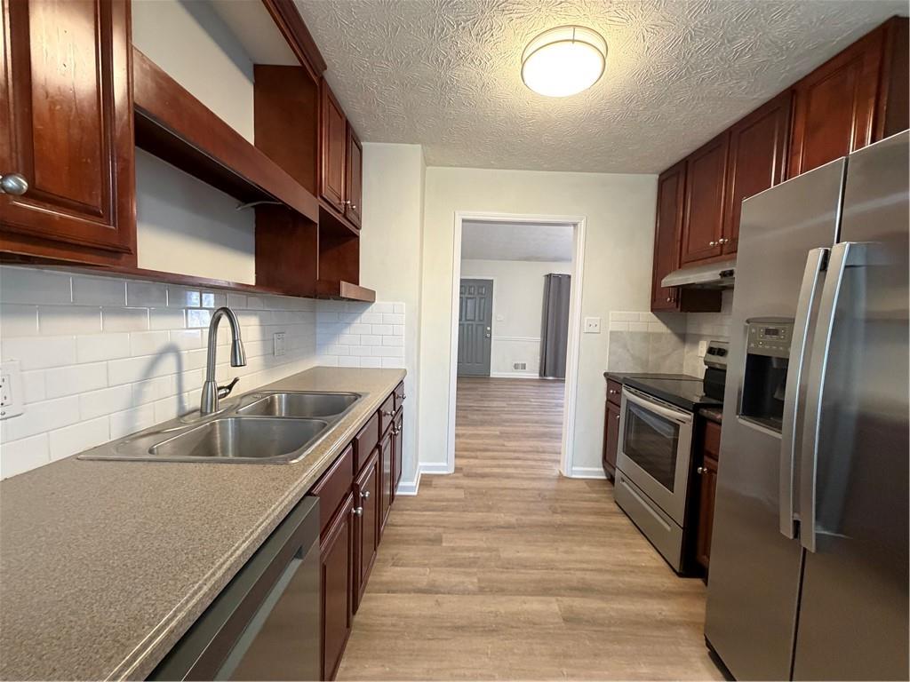 3056 Mill Falls Court Duluth, GA 30097 - Photo 13 of 31 a kitchen with granite countertop a refrigerator and a sink