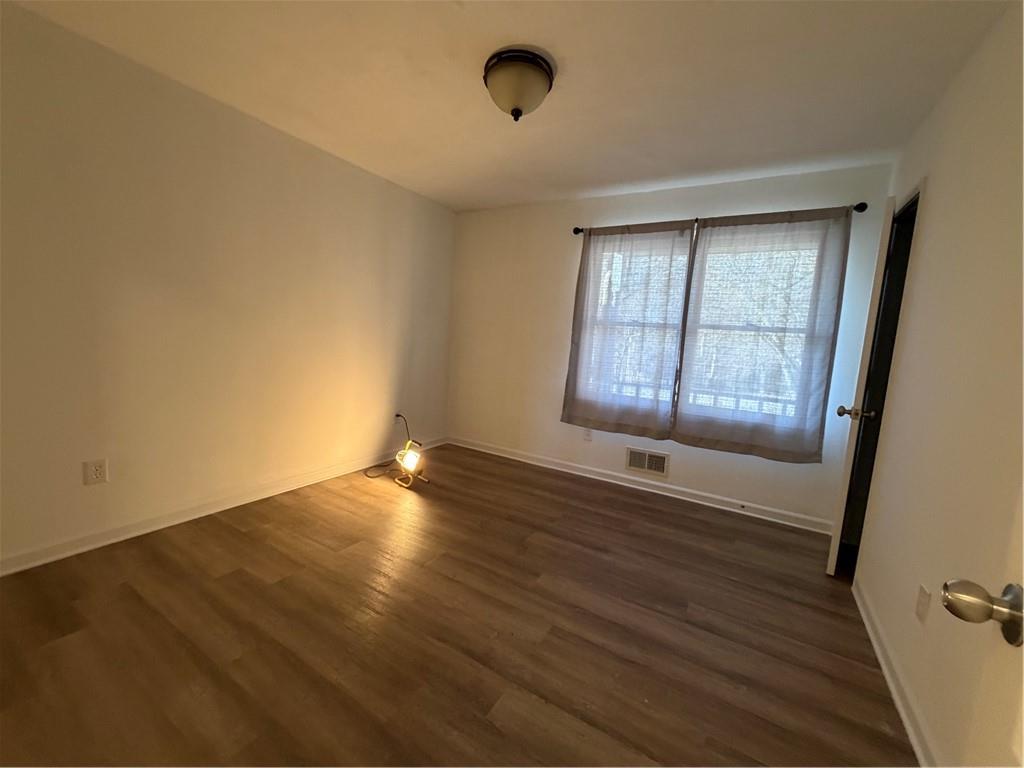 3056 Mill Falls Court Duluth, GA 30097 - Photo 16 of 31 a view of an empty room with wooden floor and a window