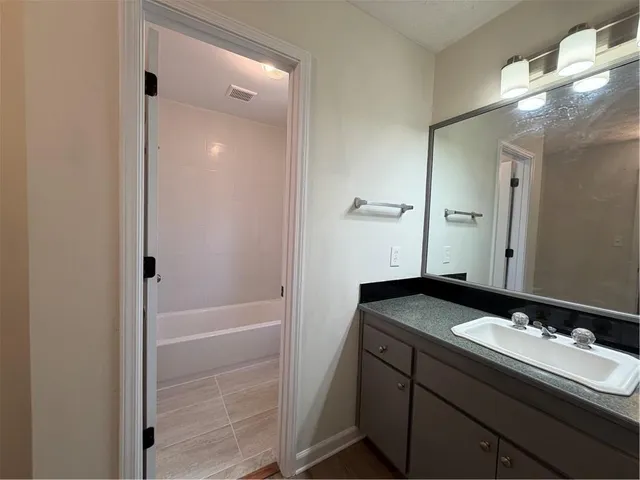a bathroom with a granite countertop sink and a mirror