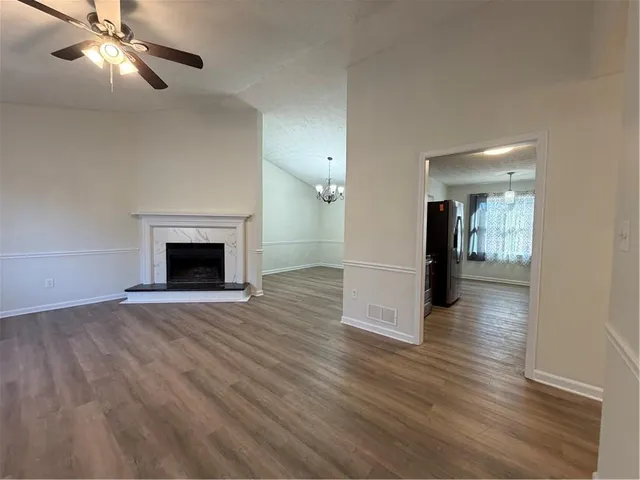 a view of empty room with wooden floor and fireplace