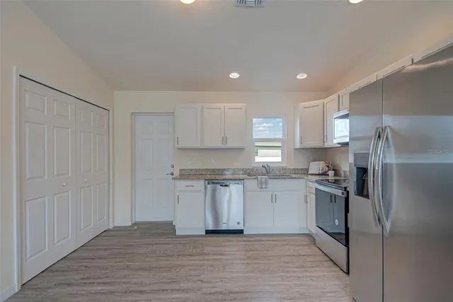 a kitchen with a refrigerator sink and cabinets