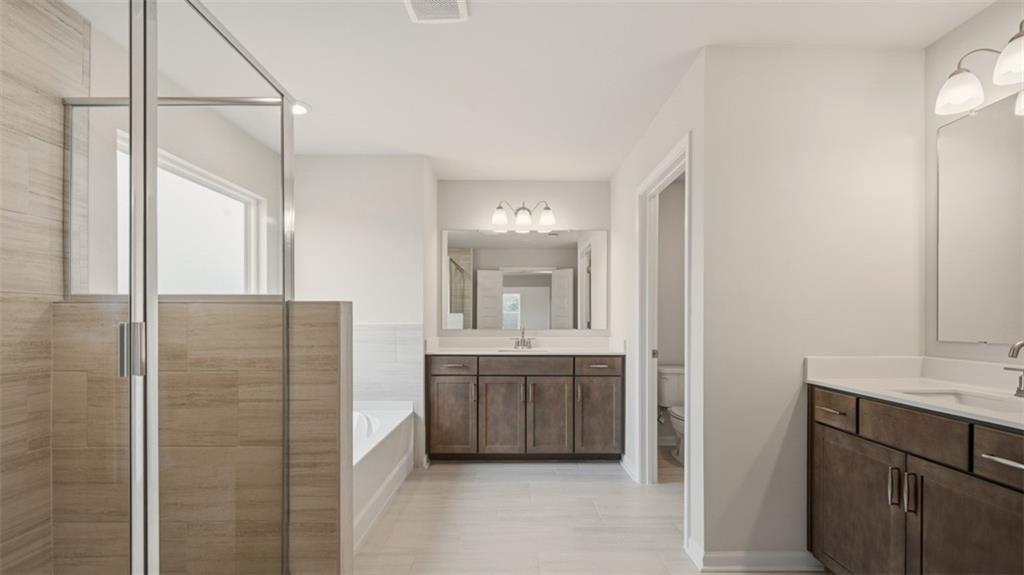 1780 Goodwin Drive Hampton, GA 30228 - Photo 35 of 40 a bathroom with a double vanity sink a mirror and a shower