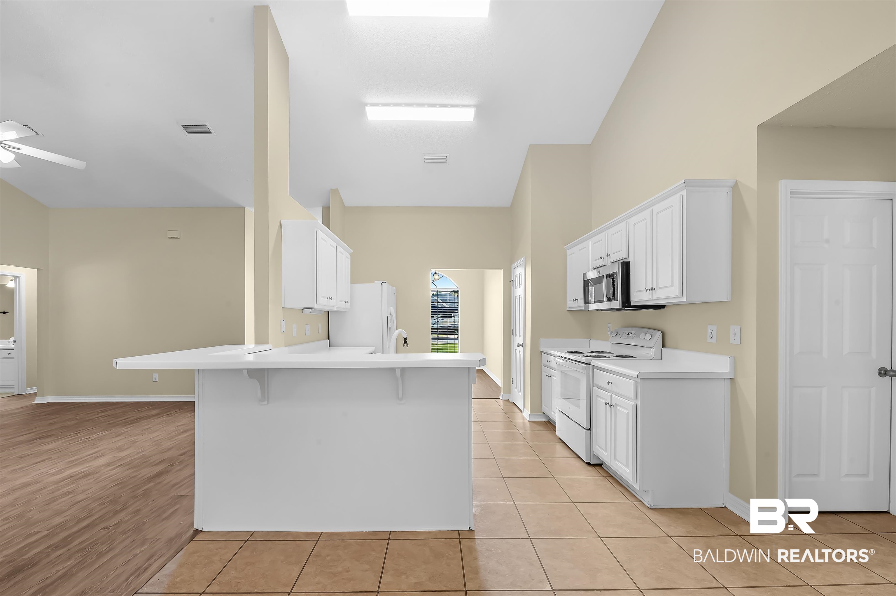 12443 Venice Boulevard Foley, AL 36535 - Photo 36 of 59 Kitchen featuring light wood-type flooring, white appliances, ceiling fan, kitchen peninsula, and a breakfast bar area