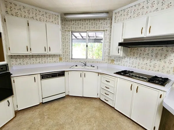 a kitchen with granite countertop white cabinets and white appliances