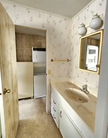 a bathroom with a granite countertop sink mirror and a shower