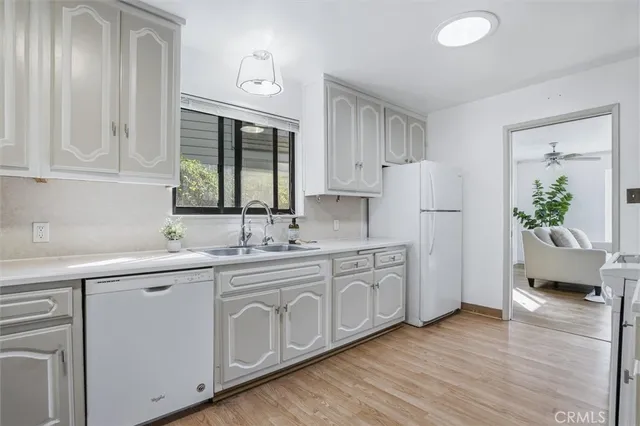 a kitchen with white cabinets and sink
