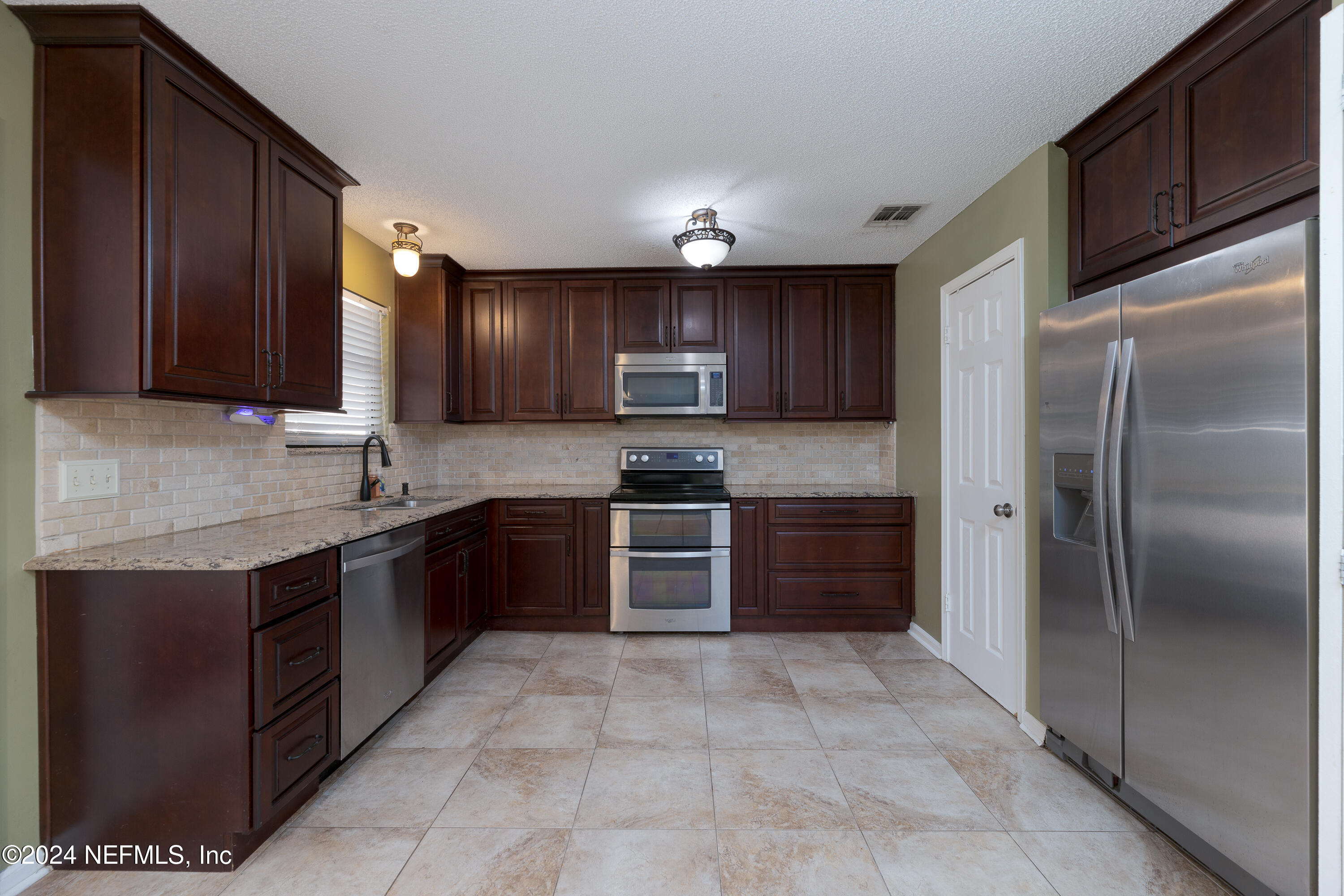 1646 Rusty Rail Road Jacksonville, FL 32225 - Photo 11 of 31 a large kitchen with stainless steel appliances granite countertop a stove refrigerator and cabinets