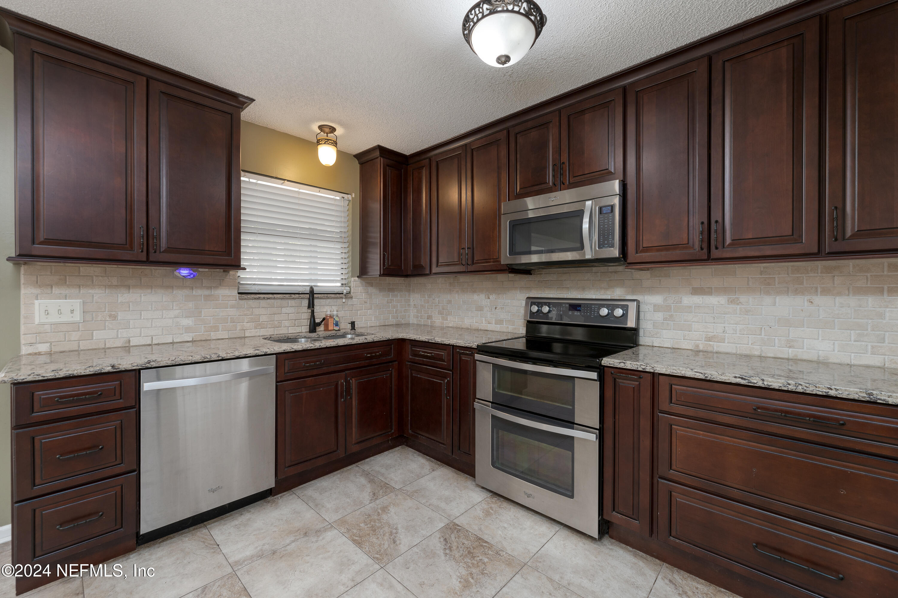 1646 Rusty Rail Road Jacksonville, FL 32225 - Photo 3 of 31 a kitchen with granite countertop wooden cabinets and stainless steel appliances
