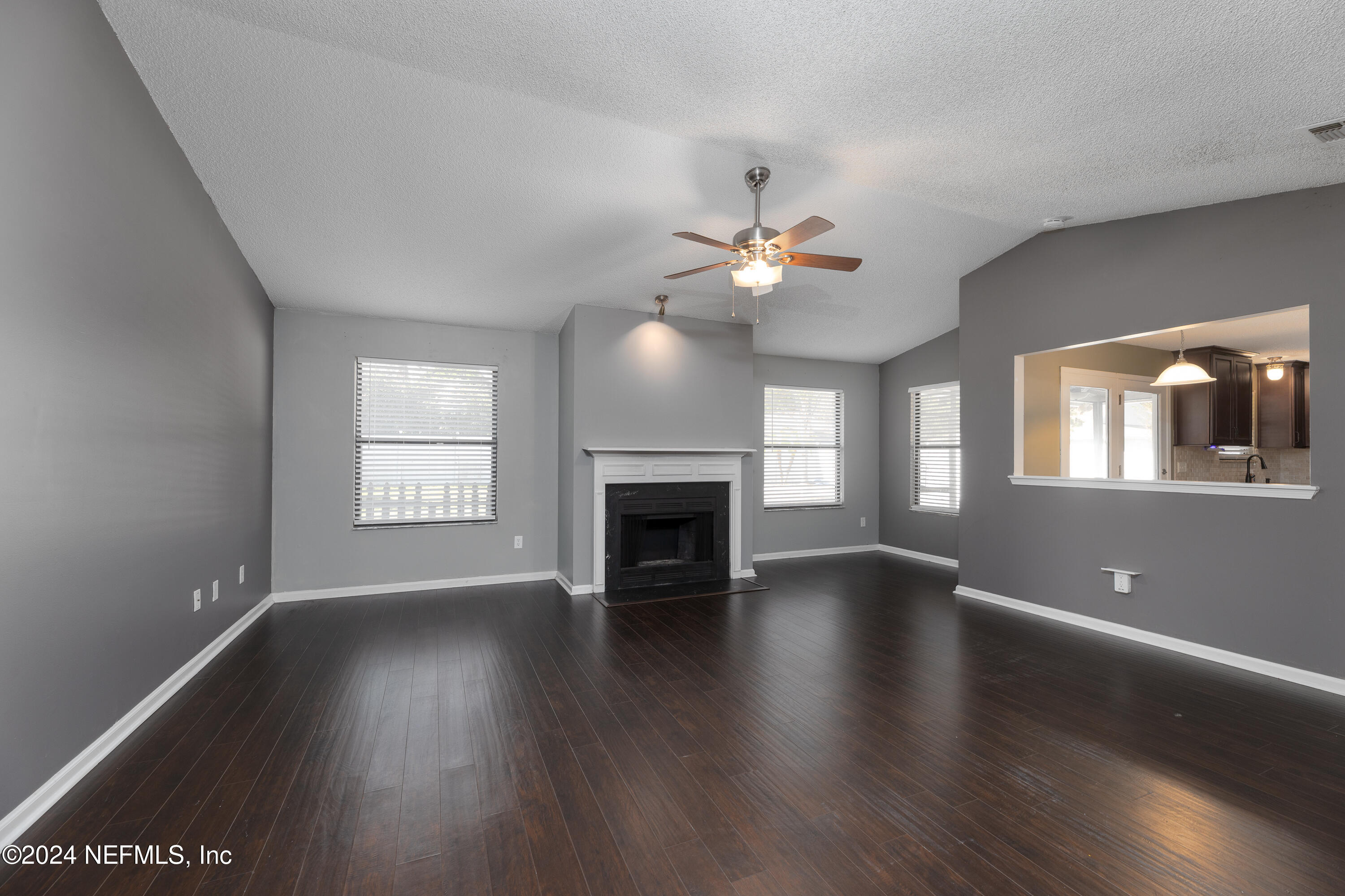 1646 Rusty Rail Road Jacksonville, FL 32225 - Photo 10 of 31 an empty room with wooden floor fireplace and windows