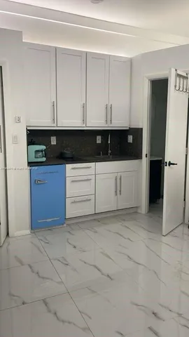 a kitchen with granite countertop a cabinets and white stainless steel appliances