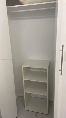 a view of walk in closet with empty racks