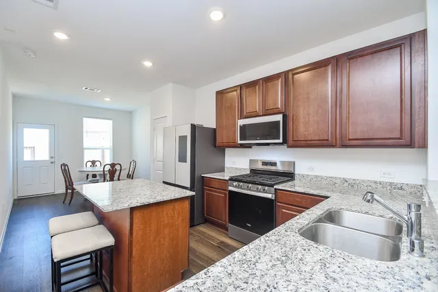 a living room with stainless steel appliances granite countertop furniture a sink a rug and a view of living room