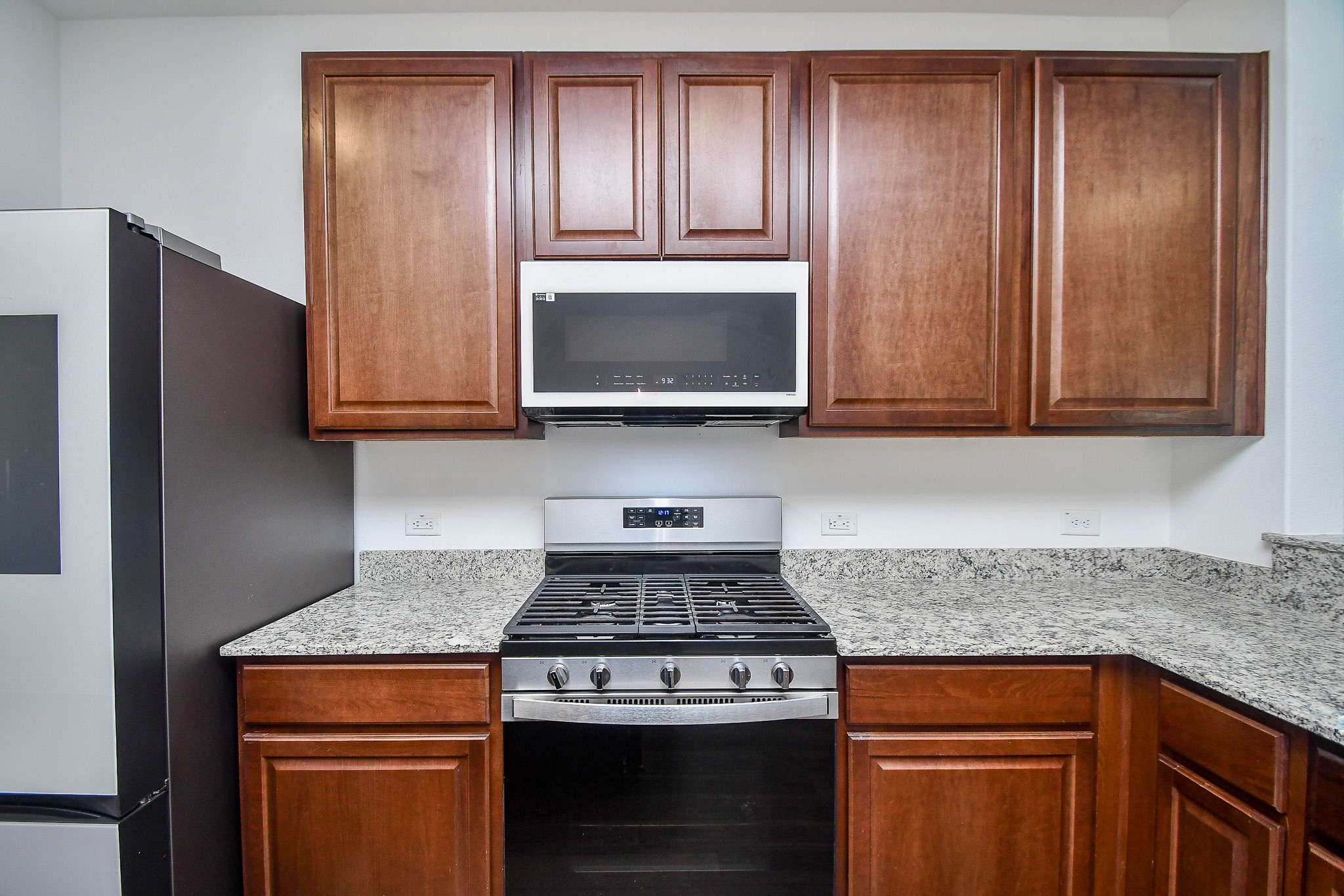 17826 Juneberry Seed Street Hockley, TX 77447 - Photo 17 of 35 a kitchen with granite countertop wood cabinets and stainless steel appliances