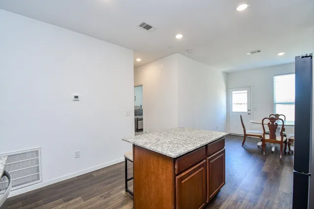 a kitchen with granite countertop a sink and a wooden floor
