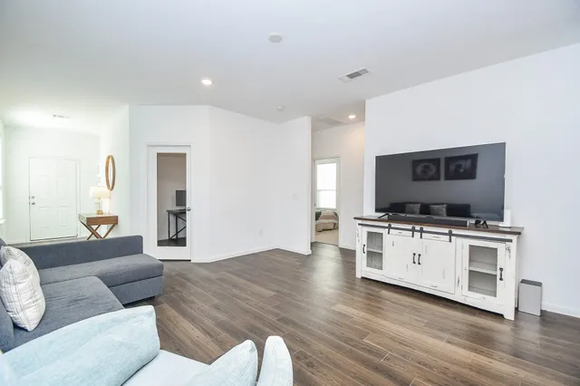 a living room with furniture and a wooden floor