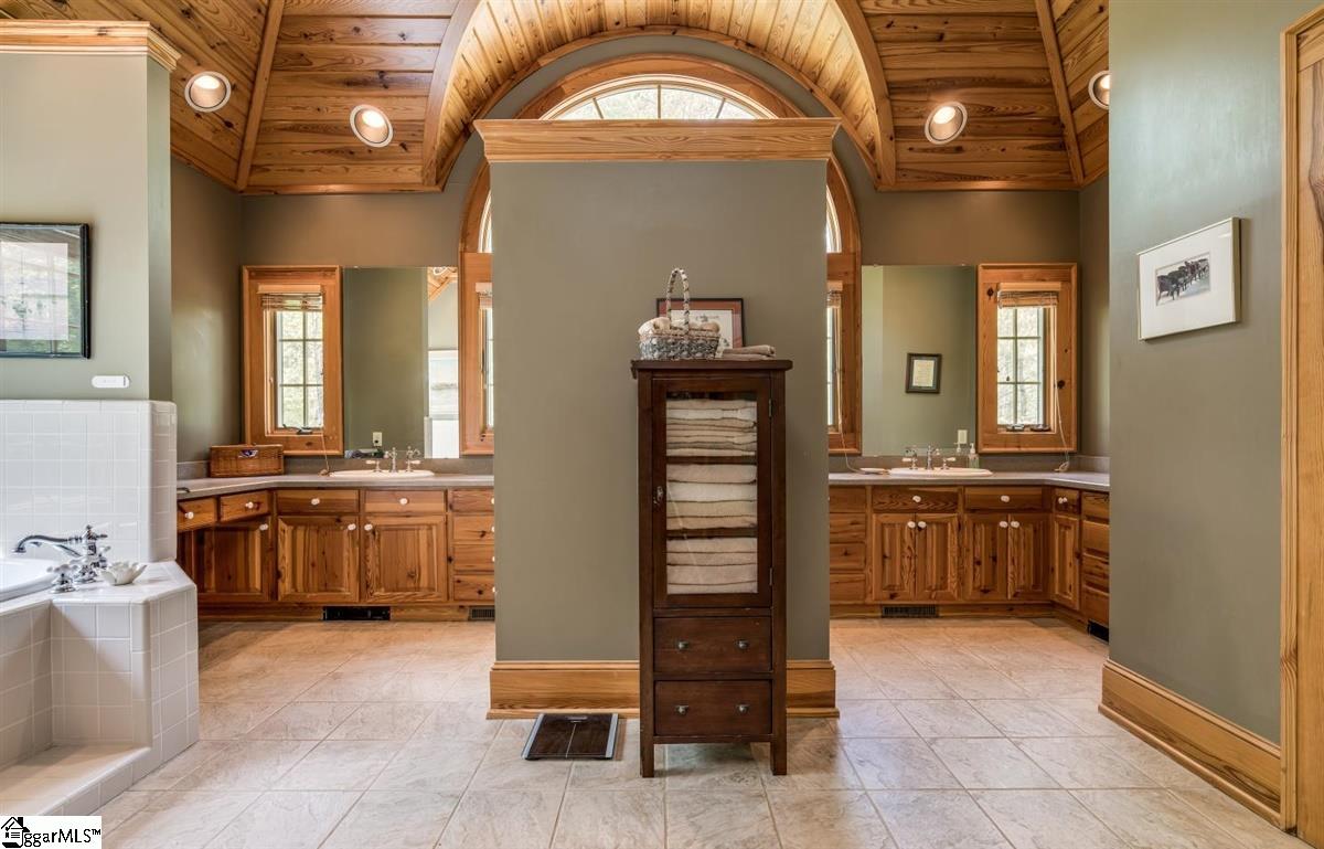 185 Hemlock Cove Road Sunset, SC 29685 - Photo 17 of 36 Master Bath with Palladium window and arched wooden ceiling draws your attention to the tall ceiling height. The shower is conveniently located in the area behind the chest in the picture and has glass doors to enter from both the right and left sides.