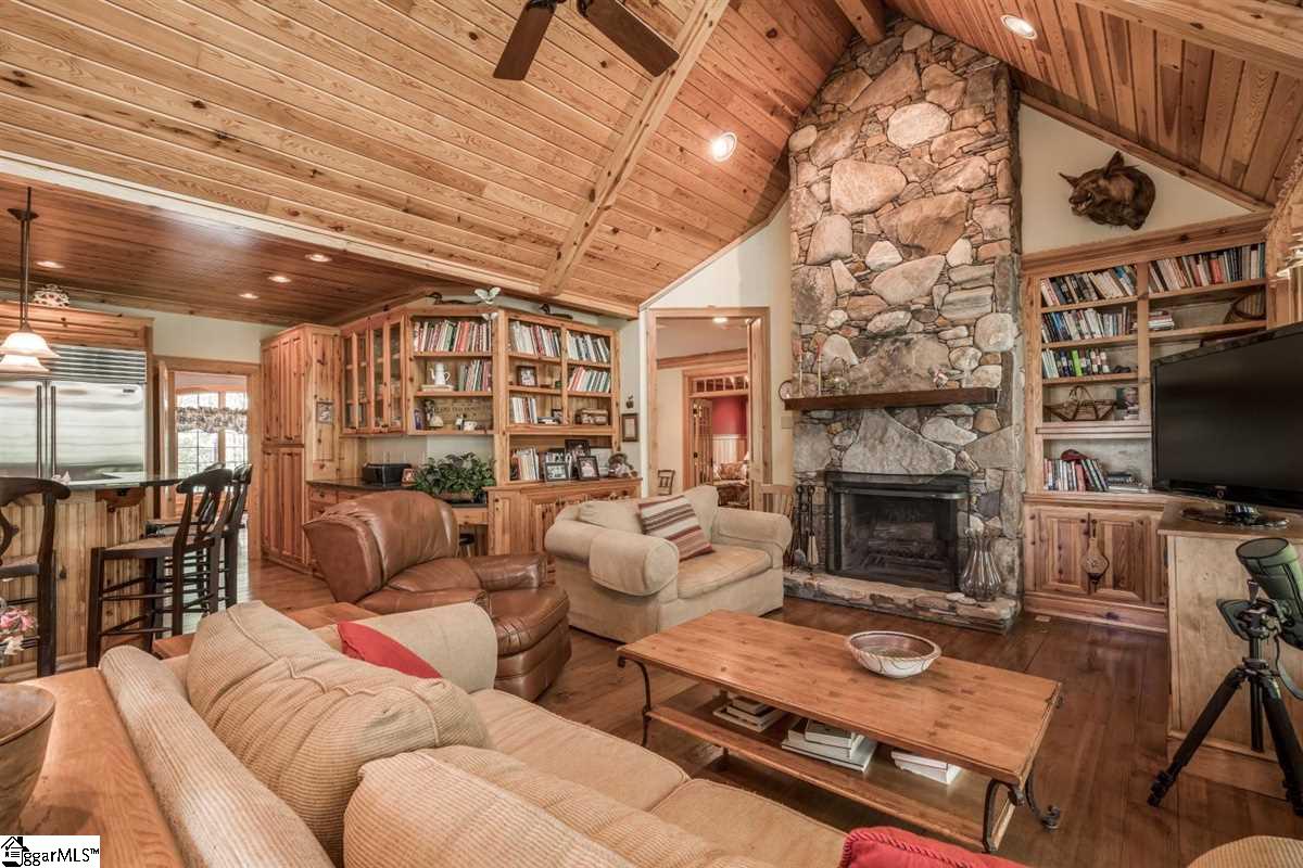 185 Hemlock Cove Road Sunset, SC 29685 - Photo 3 of 36 Natural stone fireplace with custom cabinets leads your eye up to the vaulted, wooden ceiling
