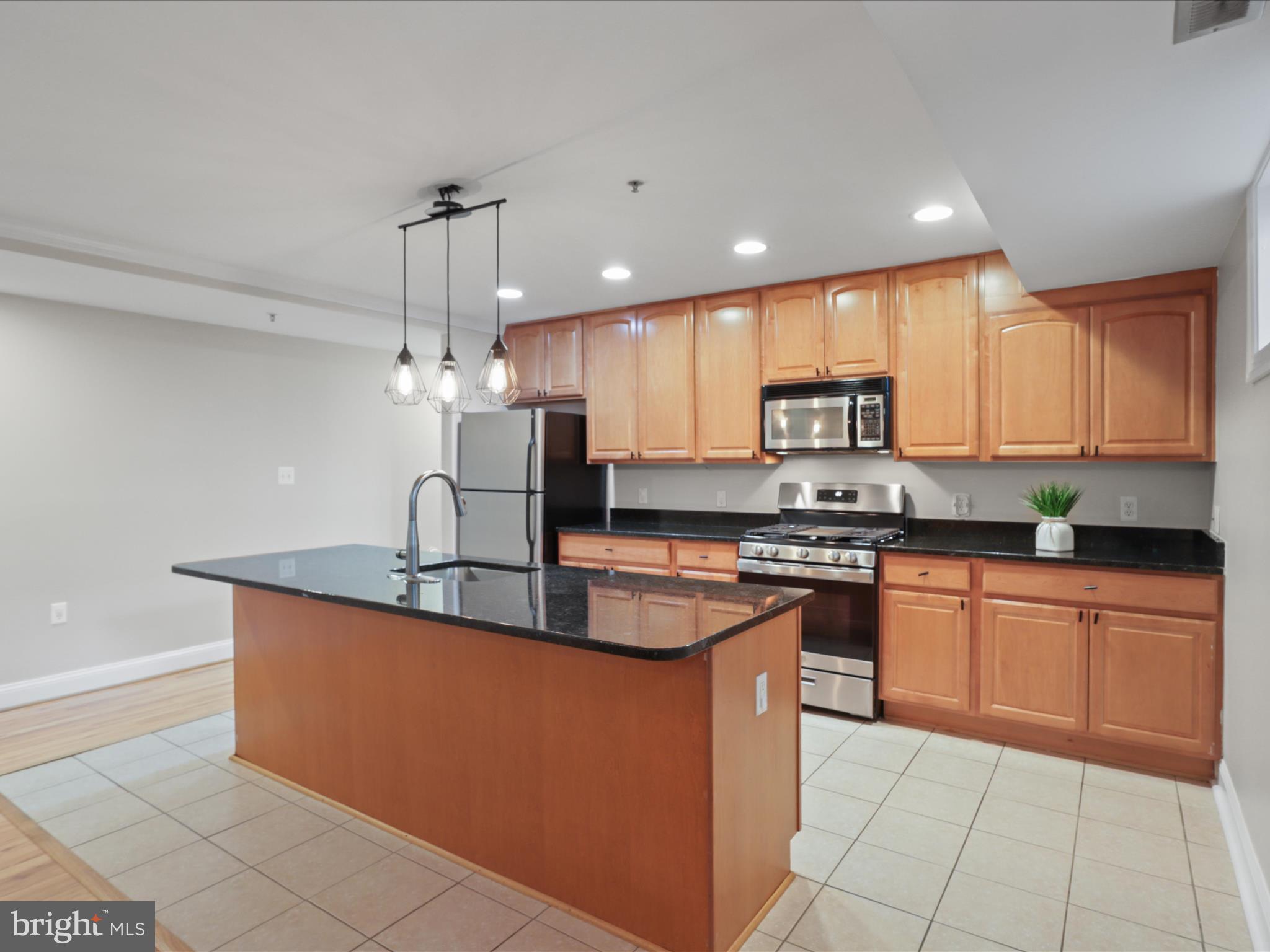 1300 Taylor Street Northwest, Unit 4 Washington, DC 20011 - Photo 11 of 35 a kitchen with stainless steel appliances granite countertop a sink a stove and a refrigerator