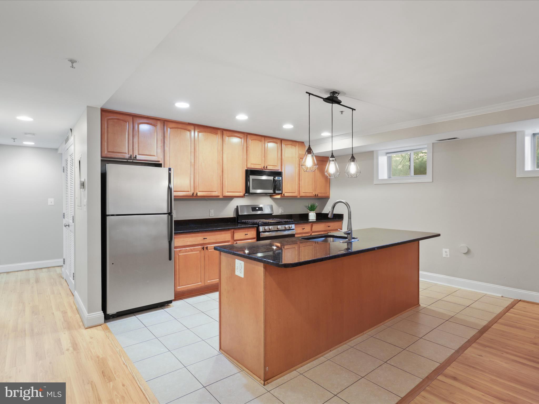 1300 Taylor Street Northwest, Unit 4 Washington, DC 20011 - Photo 12 of 35 a kitchen with stainless steel appliances granite countertop a refrigerator a sink a stove a microwave and island