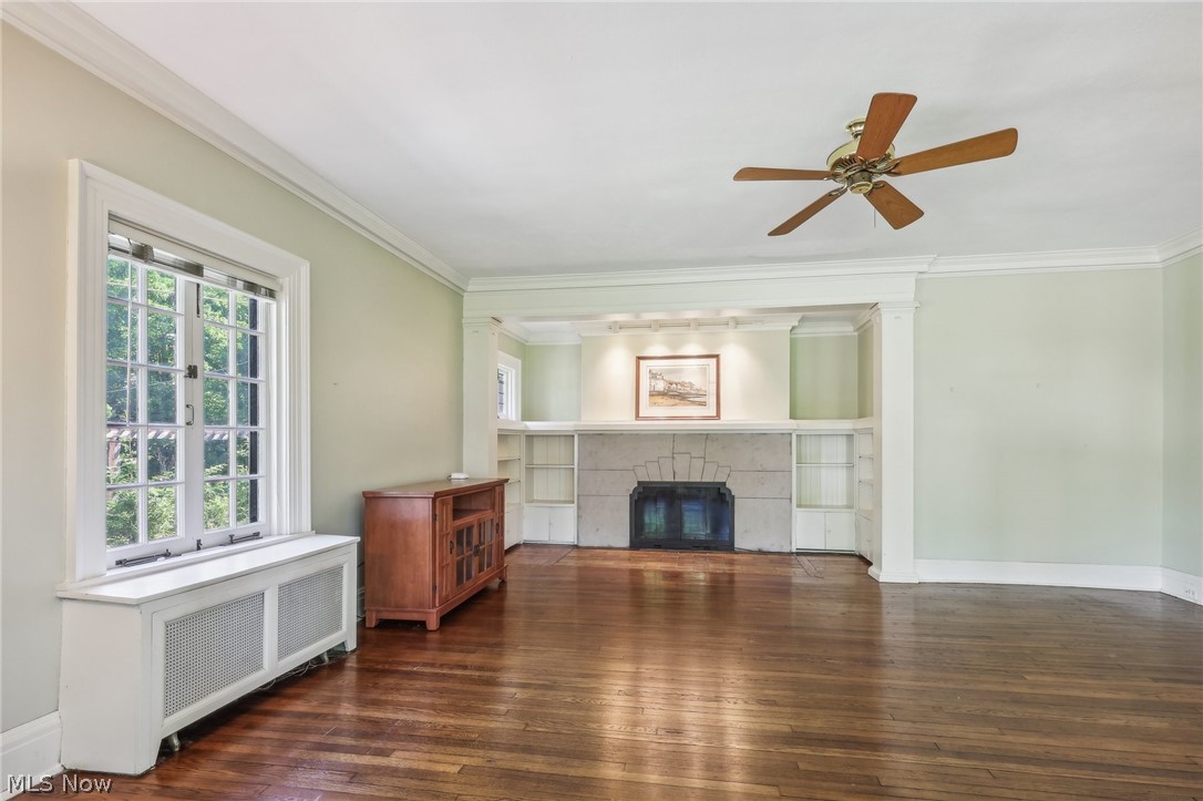 2329 Stillman Road Cleveland, OH 44118 - Photo 7 of 49 Living room featuring ceiling fan, a tiled fireplace, a wealth of natural light, and dark wood-type flooring