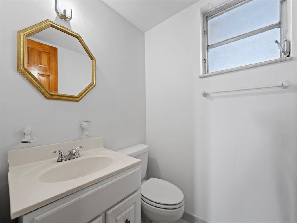 310 Fontainebleau Boulevard, Unit 502 Miami, FL 33172 - Photo 13 of 24 a bathroom with a toilet sink vanity and mirror