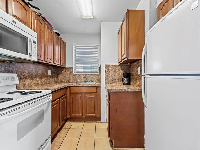 a kitchen with stainless steel appliances granite countertop a refrigerator sink and stove