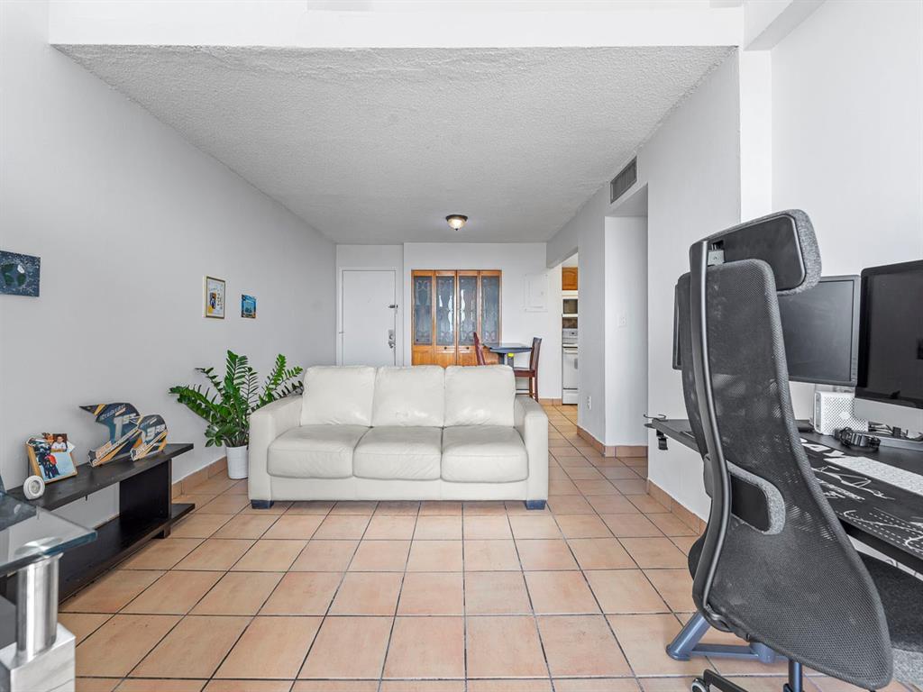 310 Fontainebleau Boulevard, Unit 502 Miami, FL 33172 - Photo 6 of 24 a living room with furniture and a flat screen tv