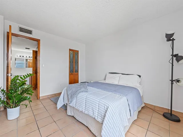 a bedroom with a bed and a potted plant