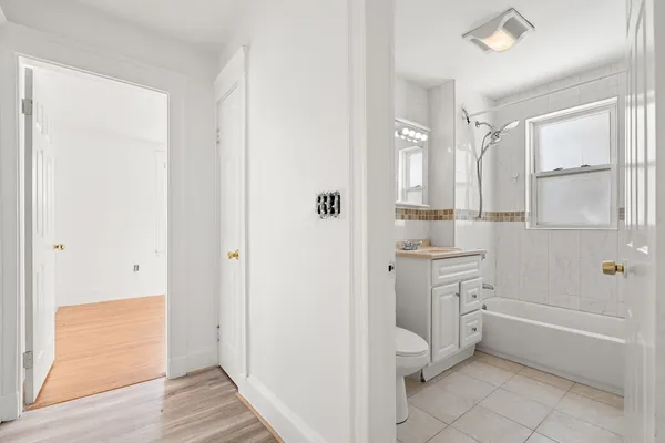 a bathroom with a granite countertop bathtub shower and toilet