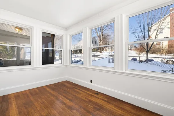 a view of a living room with furniture and large windows